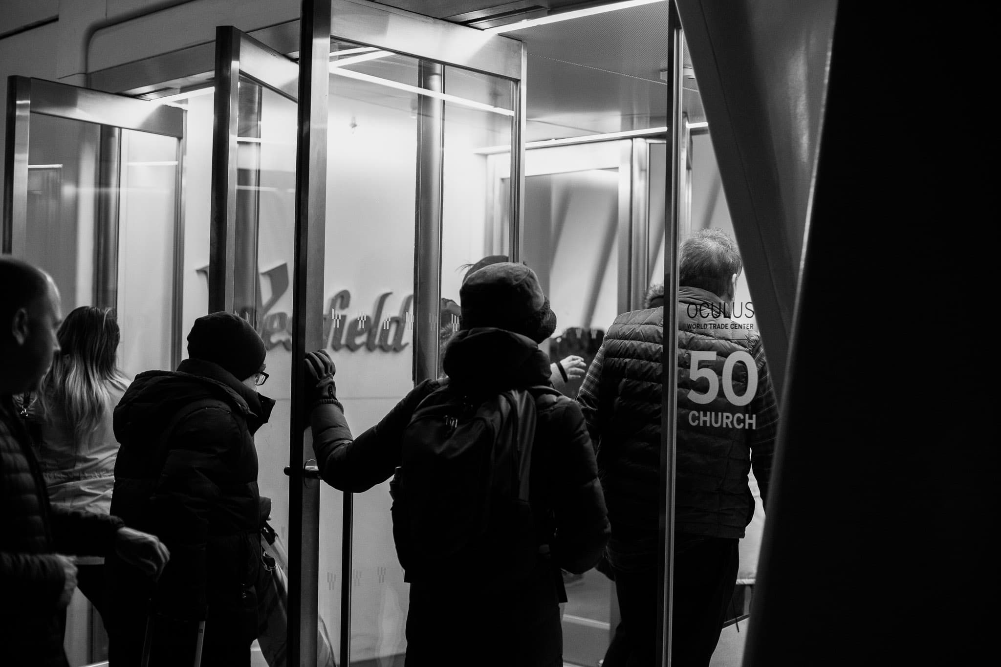 Many people walking through Westfield Oculus' entrance.